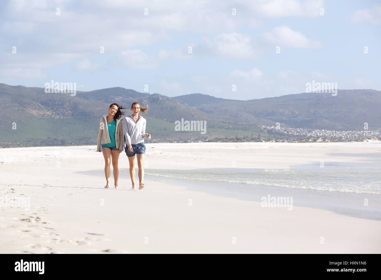 Portrait de deux amies, marcher sur la plage vide ensemble Banque D'Images