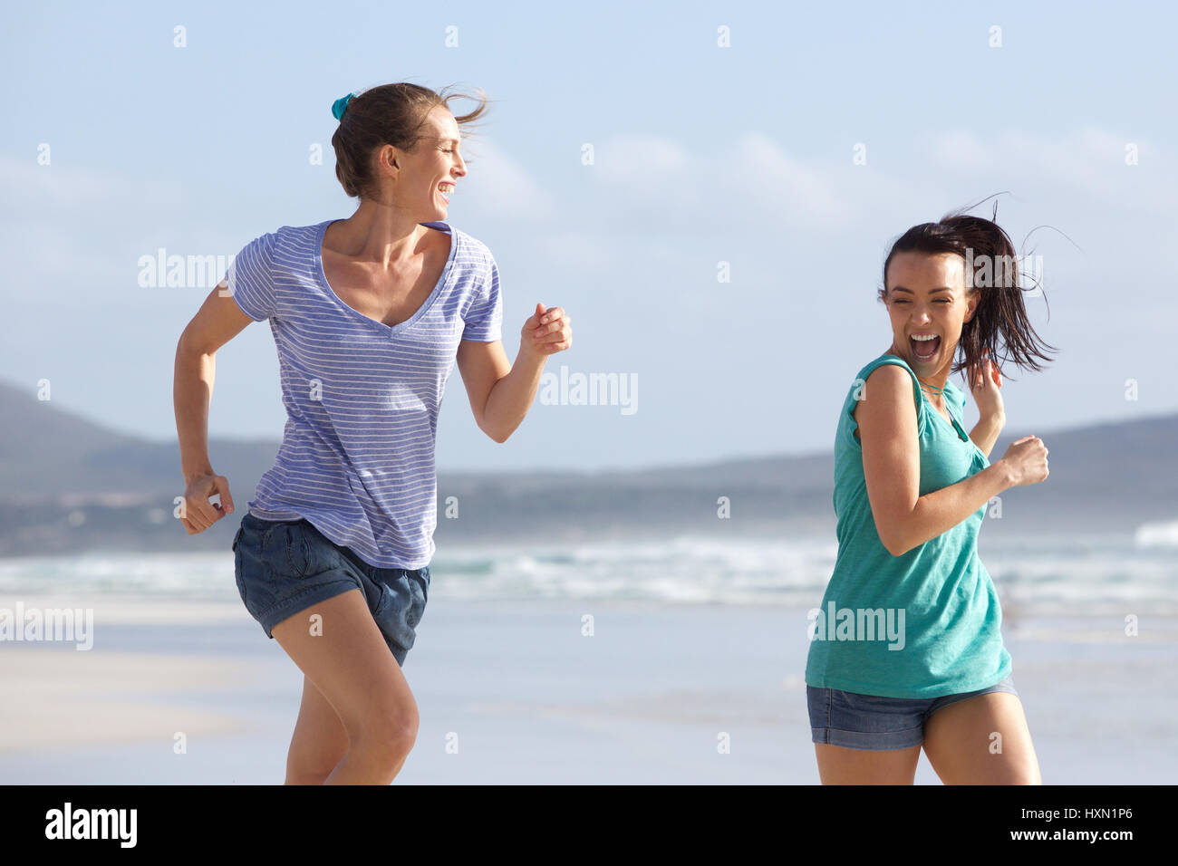 Portrait de deux amis courir en été à la plage Banque D'Images
