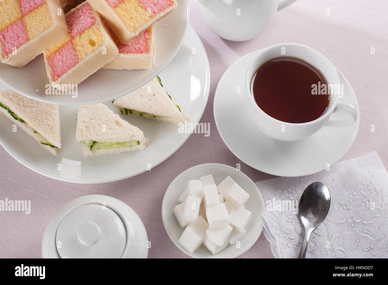 Plateau avec des morceaux de sucre et des collations à l'heure du thé anglais de sandwichs au concombre et battenburg gâteaux Banque D'Images