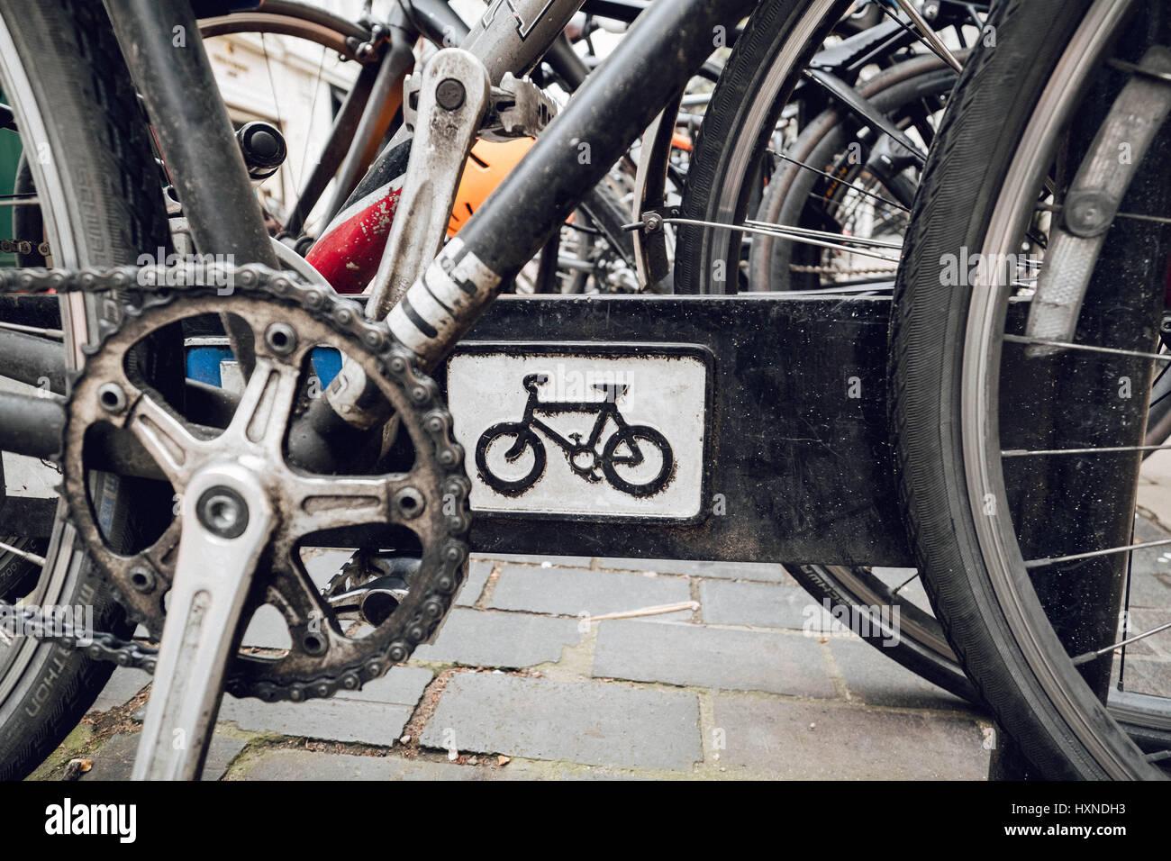 Photographie couleur de un gros plan d'un vélo / symbole signe sur un porte vélo et les nombreux vélos qui l'entourent. Banque D'Images