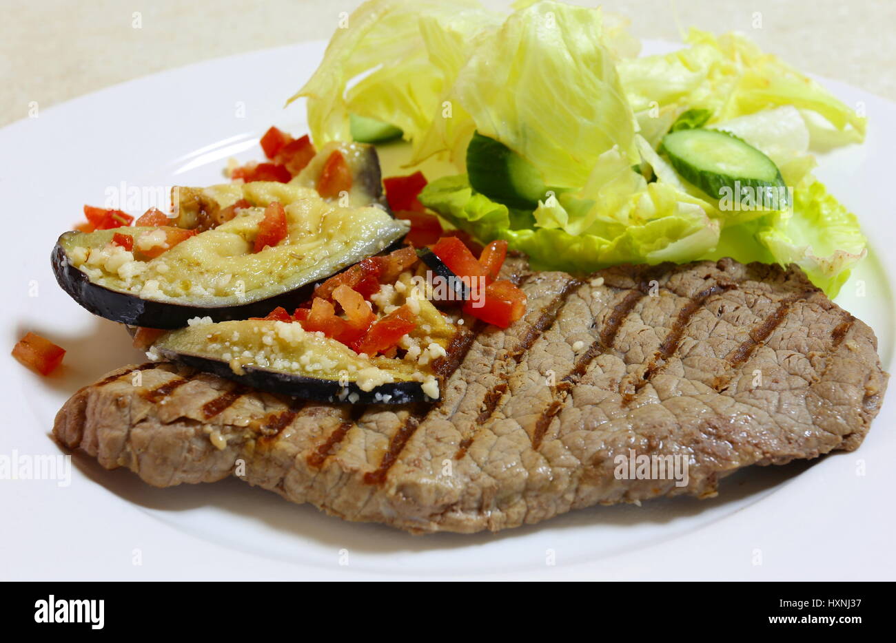 Steak minute grillé garni de tranches d'aubergines sautées (aubergine