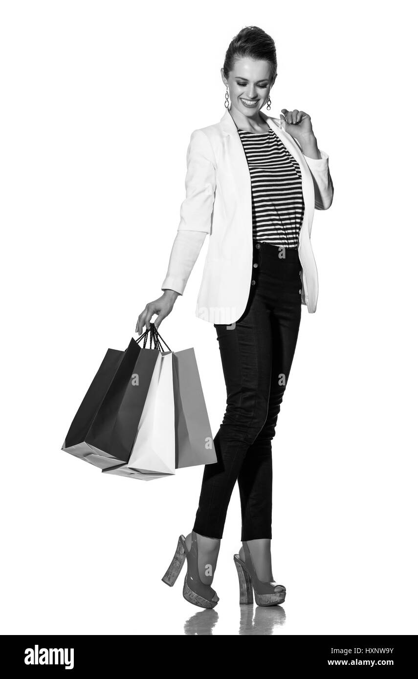 Le Shopping. L'approche française. Full Length portrait of smiling young woman with shopping bags les couleurs du drapeau français contre fond blanc Banque D'Images