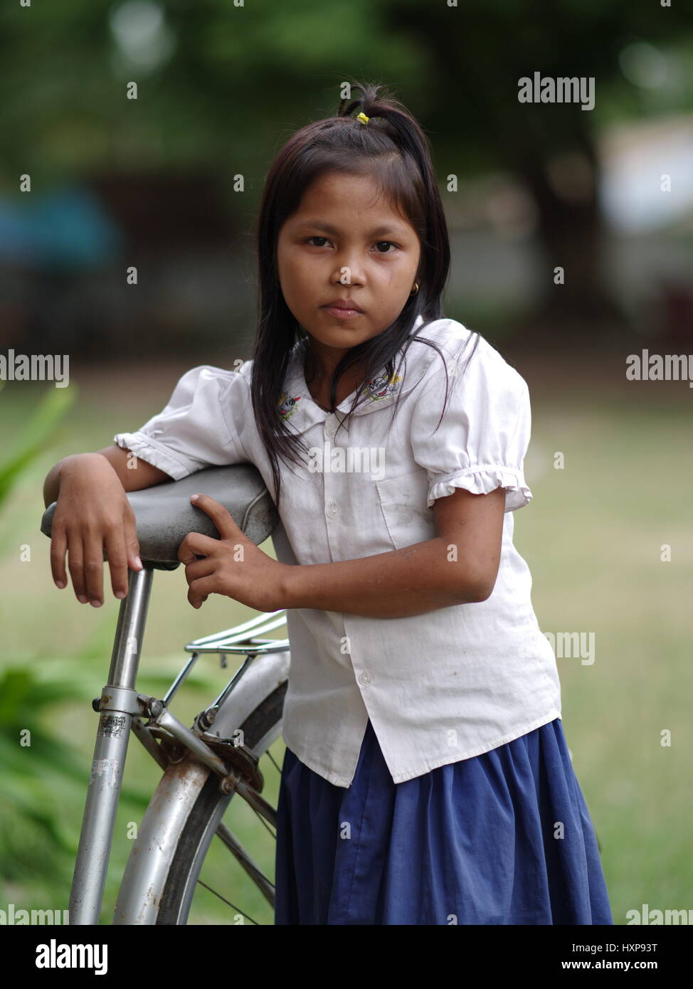 Cambodgien Khmer fille de l'école en dehors de l'école traditionnelle dans le sud du Cambodge sur son vélo. Les enfants au Cambodge porter des uniformes scolaires traditionnels. Banque D'Images