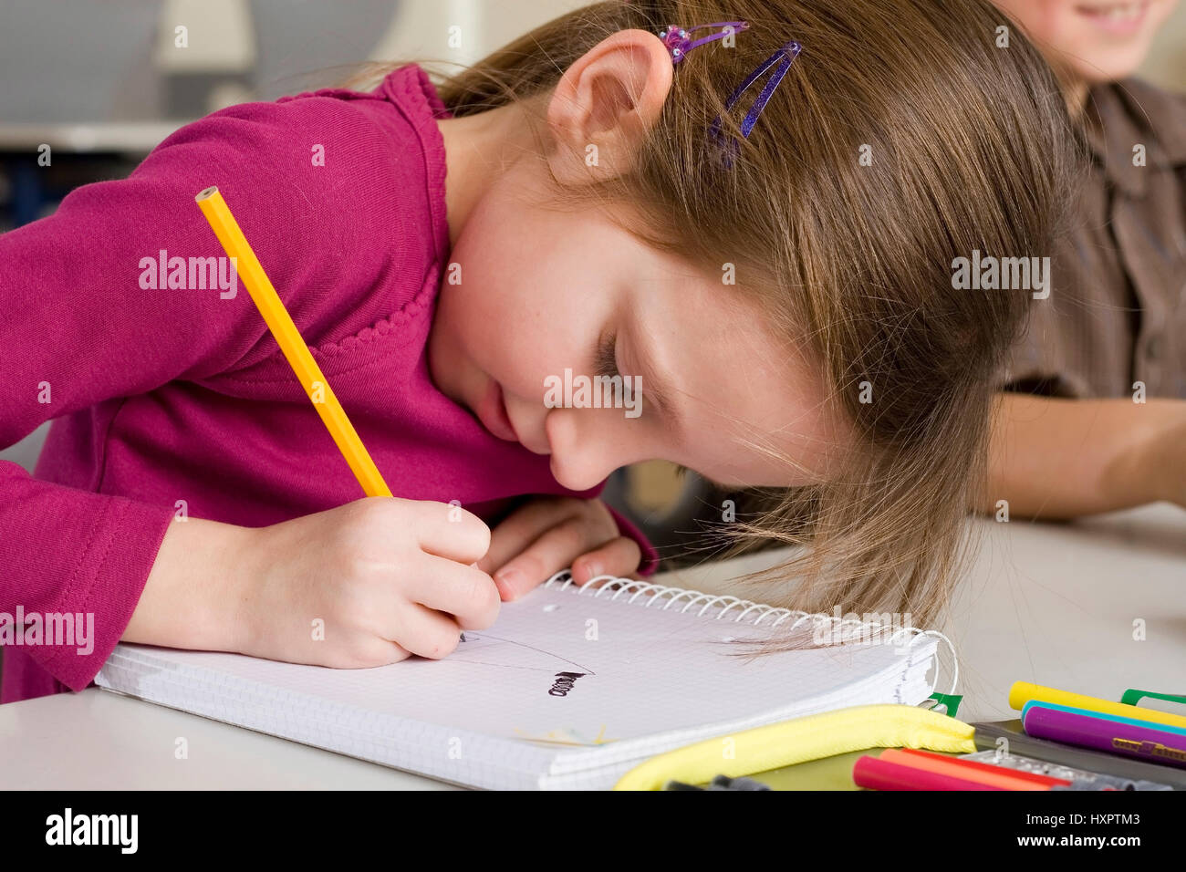 6-year-old girl écrit concentré dans la salle de classe (MR), sechsjähriges Mädchen im Klassensaal angestrengt schreibt (Mr) Banque D'Images