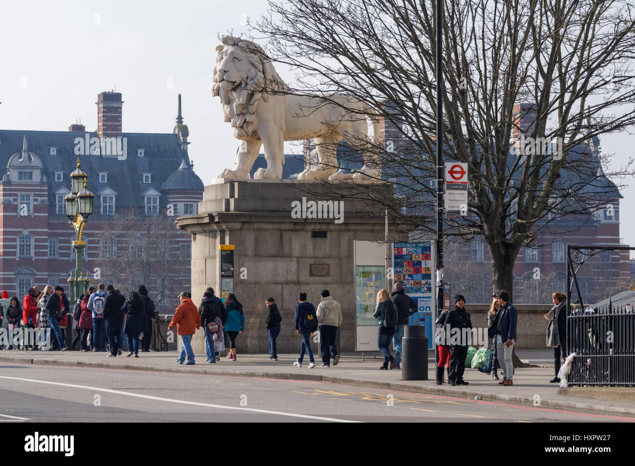 Les gens passent la rive sud Lion sur le pont de Westminster, Londres Angleterre Royaume-Uni UK Banque D'Images