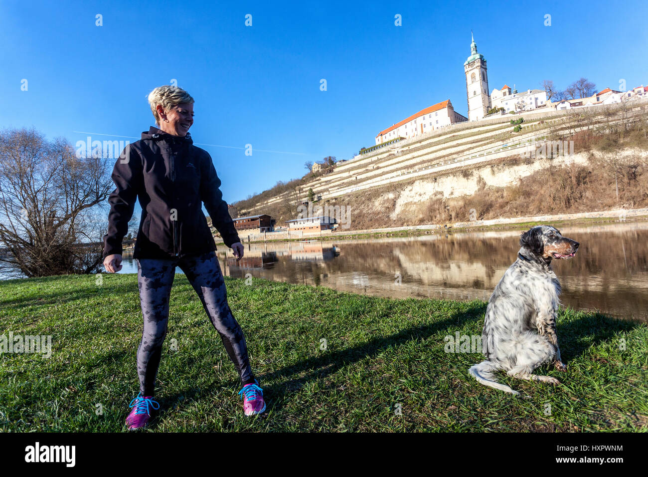 Femme sur une promenade autour de la rivière avec son Setter Irlandais, Château Melnik en arrière-plan, la République tchèque, l'Europe Banque D'Images