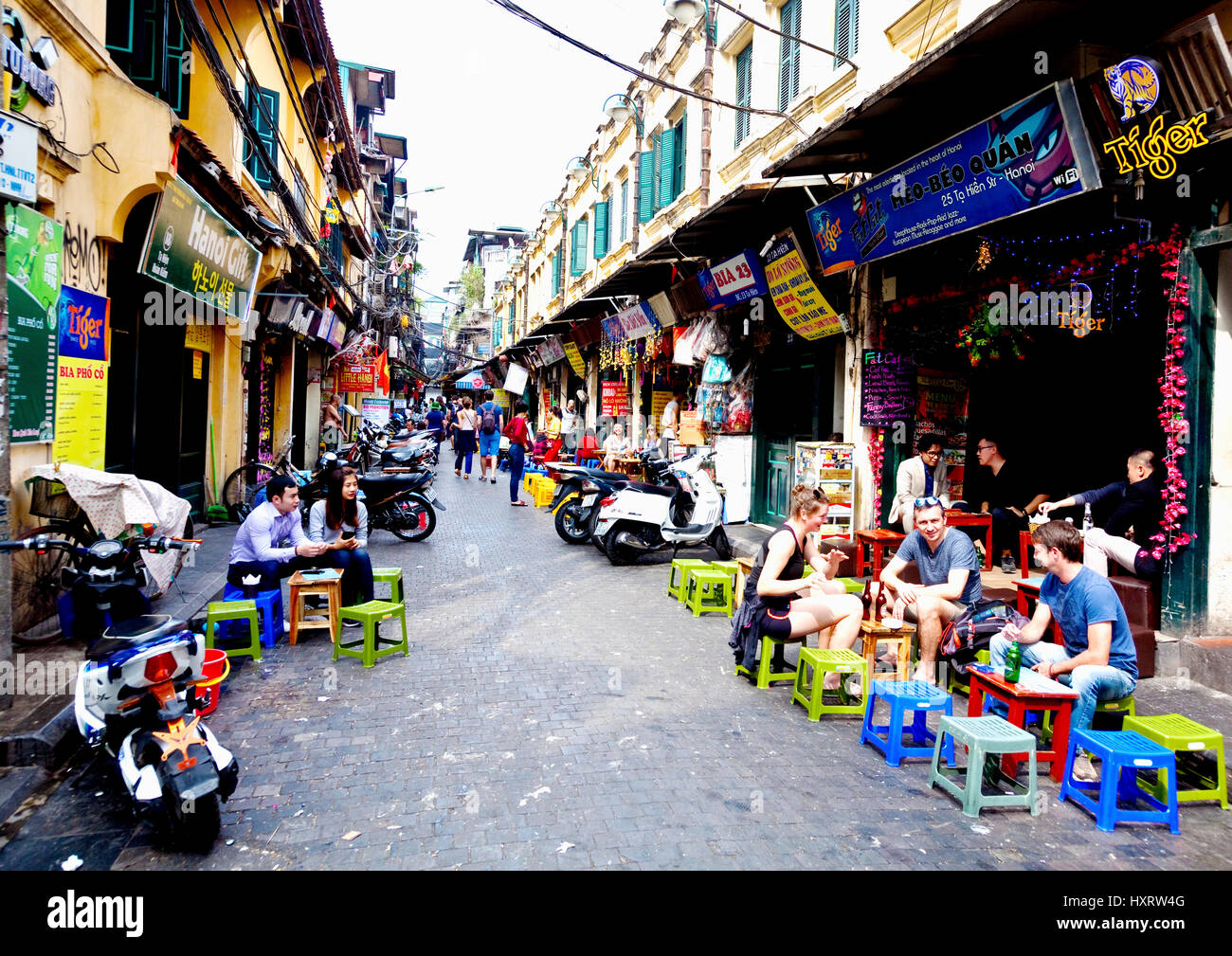 Les touristes profiter de rafraîchissements à Hanoi rue latérale Banque D'Images