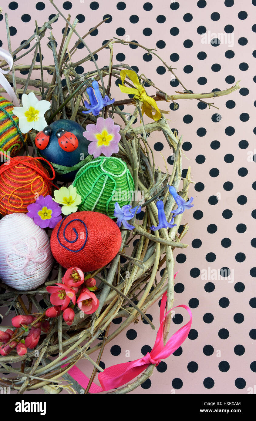 Décorations de Pâques oeufs dans leur nid sur rose et noir tissu dot Banque D'Images