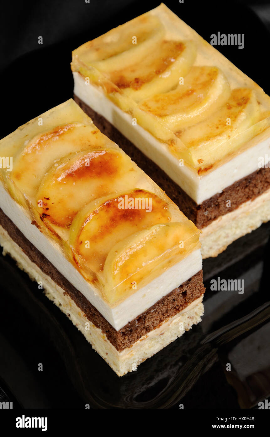 Empilées de gâteau au caramel, chocolat, mousse de pomme et amande biscuit avec une couche de gelée de pommes caramélisées tranches Banque D'Images