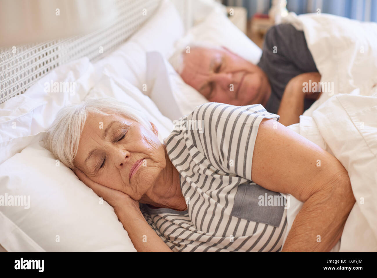 Senior couple endormi dans leur lit à la maison Banque D'Images
