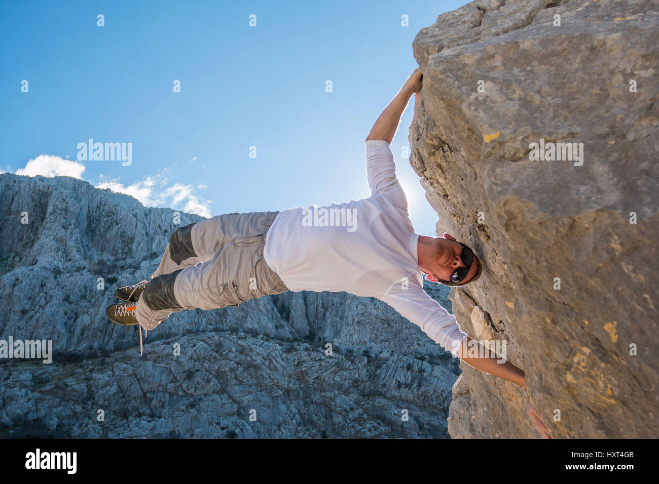 Jeune homme escalade de rochers et suspendues au-dessus de gap. Roao, Villanueva del Rosario, Málaga Banque D'Images