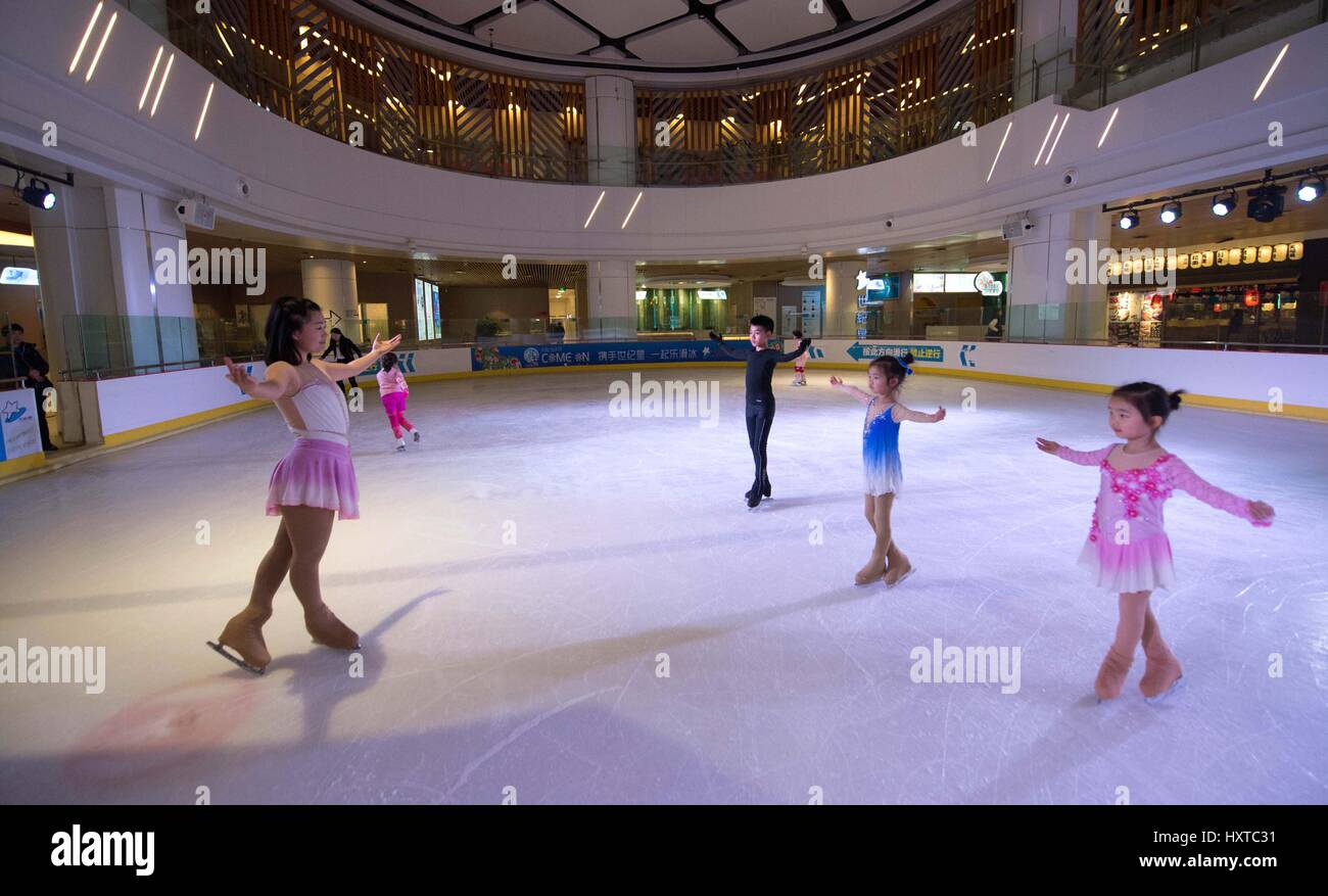 (170330) -- KUNMING, 30 mars 2017 (Xinhua) -- ge Entraîneur Qian (L) enseigne aux enfants patinage artistique dans la patinoire Star Siècle à Kunming, capitale du sud-ouest de la province chinoise du Yunnan, le 9 mars 2017. La promotion de 300 millions de personnes qui fréquentent les sports d'hiver est un grand pas de Chinese National Programme de remise en forme. Le sud-ouest de la province chinoise du Yunnan intègre les sports d'hiver, un programme de remise en forme et de l'écotourisme et encourage les entrepreneurs sociaux d'investir dans des patinoires et des stations de ski. À l'heure actuelle, le Yunnan a 3 patinoires et 3 autres sont en construction. Yunnan Qujing envisage de construire une formation sur mesure Banque D'Images