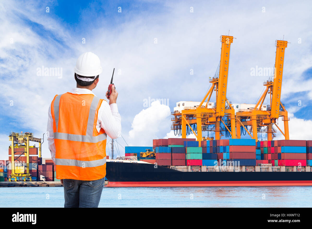 Docker en conversation sur le talkie-walkie pour contrôler le chargement de conteneur dans un port industriel Banque D'Images