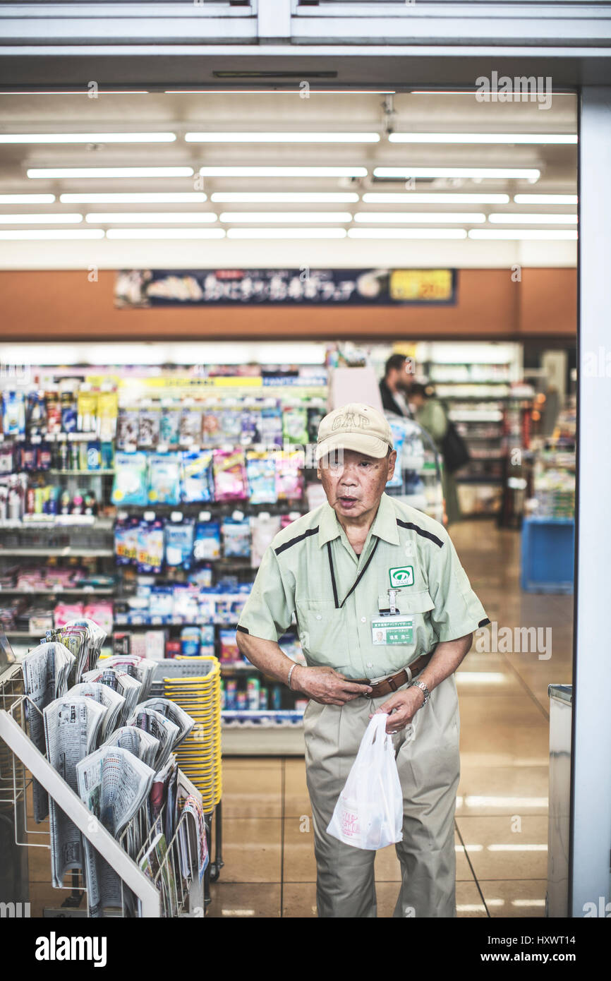 L'homme japonais qui sortent d'un magasin à Tokyo, Japon. Banque D'Images