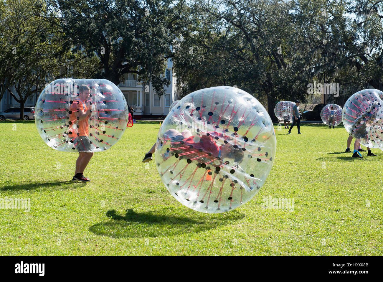 Personnes jouant "dernier homme debout" bubble ball jeu de Forsyth Park, Savannah, Géorgie. Banque D'Images