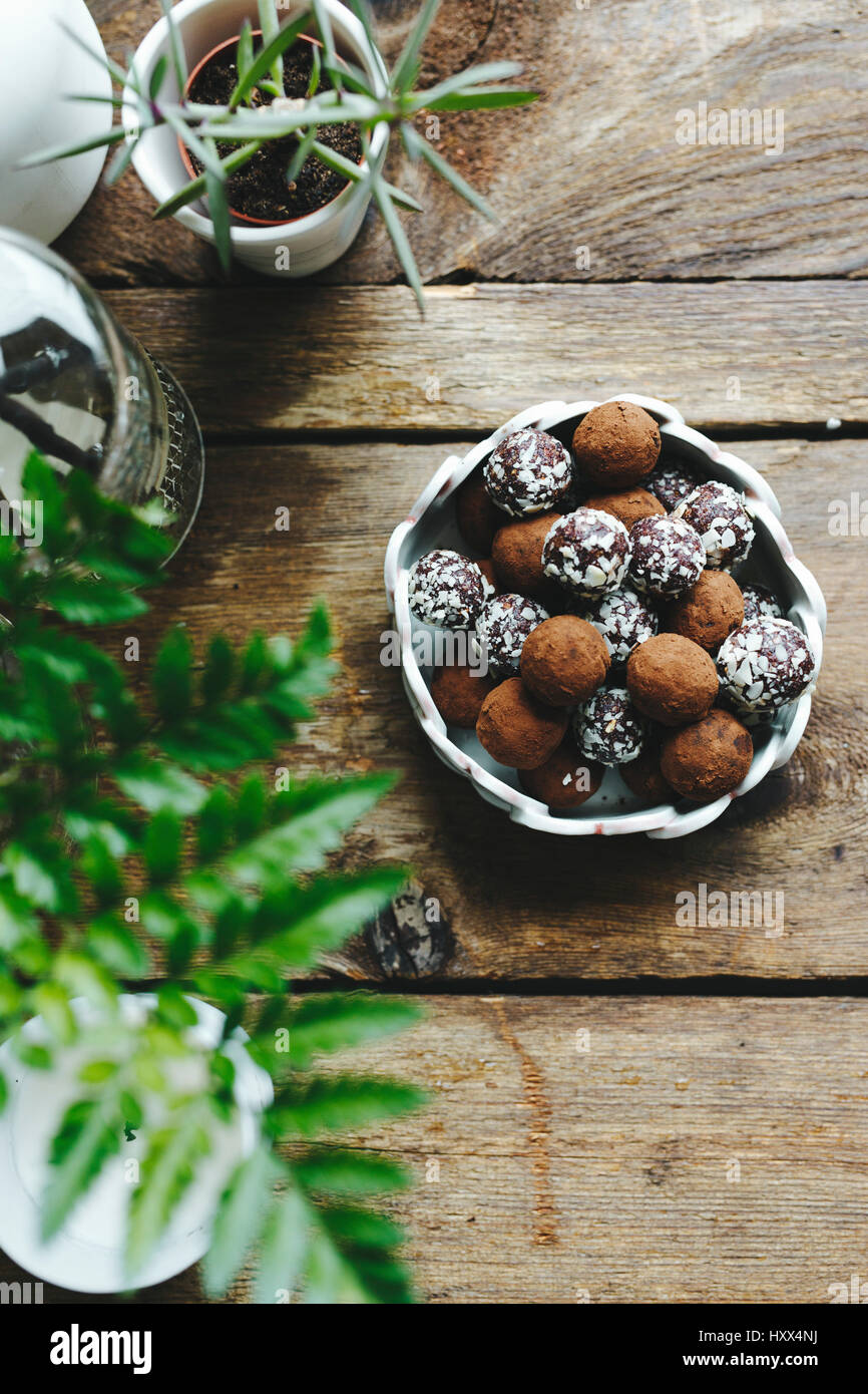 Truffes au chocolat recouvert de noix, sur une table en bois. Banque D'Images