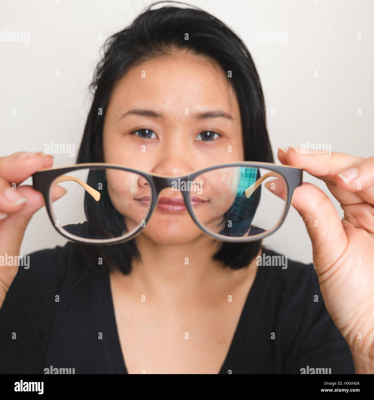 Asian woman taking off lunettes, verres préparation Banque D'Images