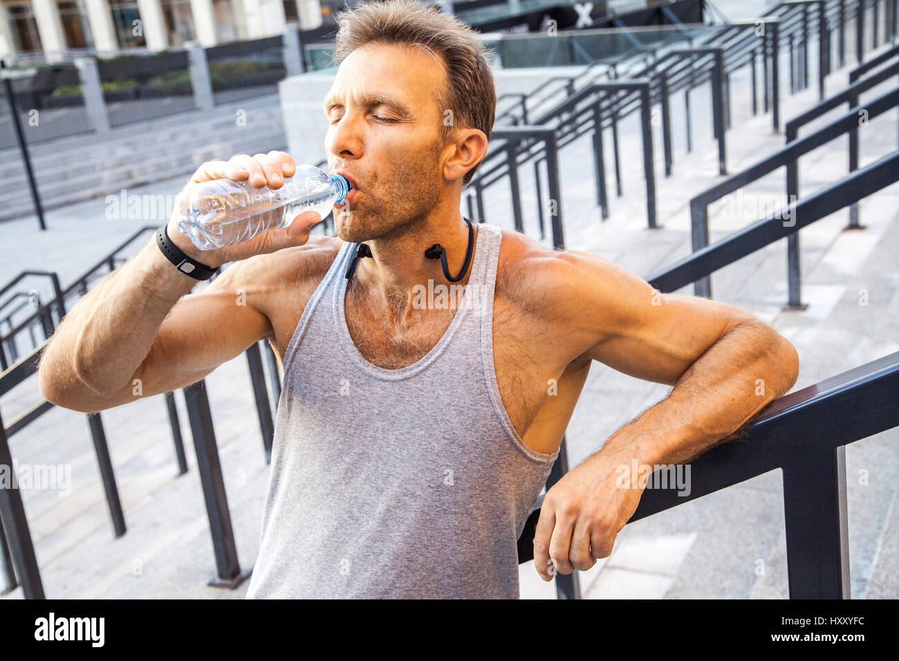 Soif sportsman prendre un repos et de l'eau potable après l'exécution. fitness, le sport, l'exercice et les personnes de vie sain concept. Banque D'Images