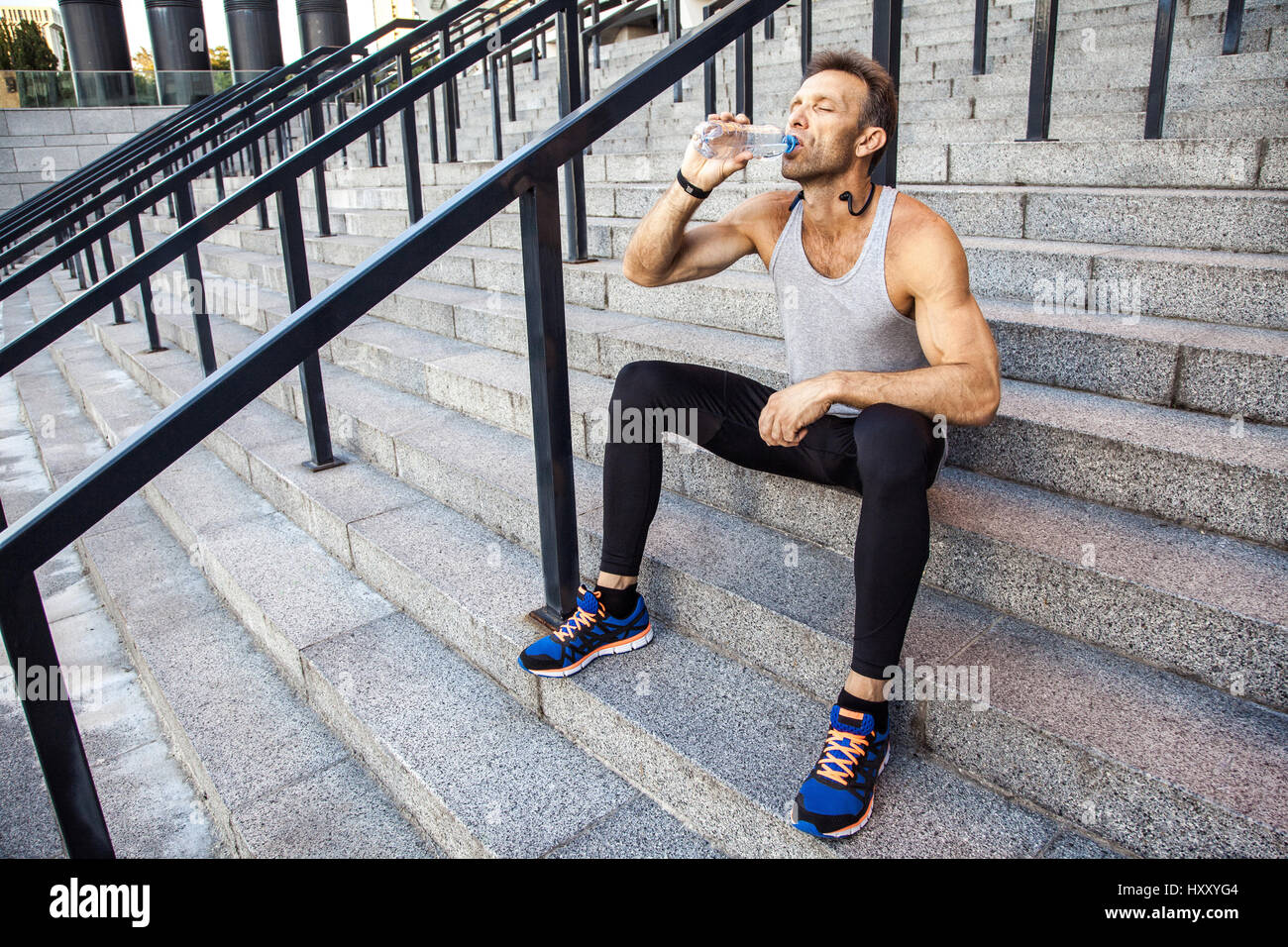 Soif sportsman prendre un repos et de l'eau potable après l'exécution. fitness, le sport, l'exercice et les personnes de vie sain concept. Banque D'Images