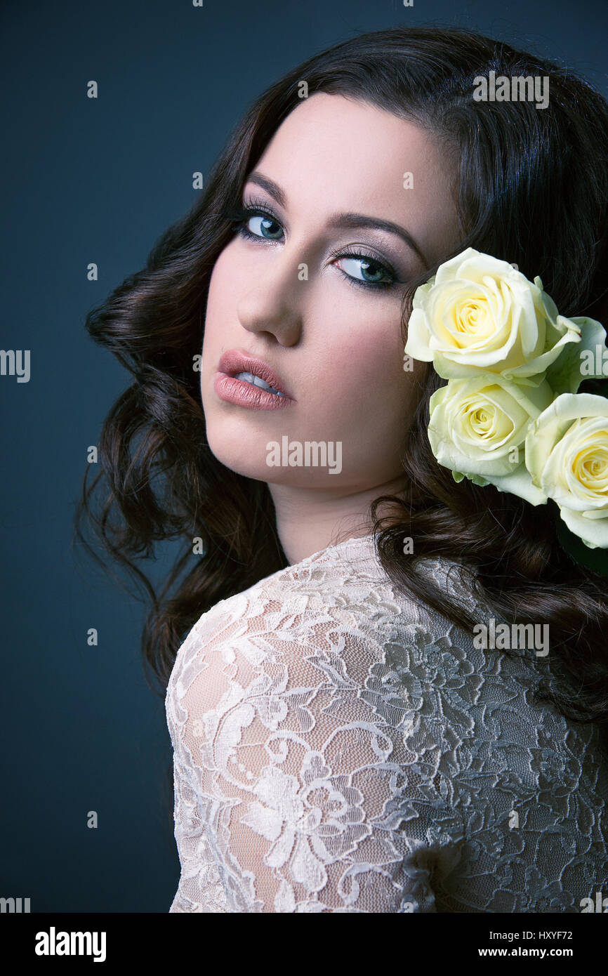 Girl robe dentelle blanche avec des cheveux longs, avec une rose dans ses cheveux Banque D'Images