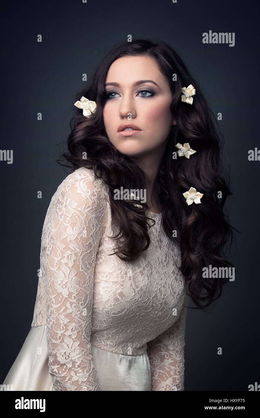 Woman wearing white lace dress, looking away Banque D'Images