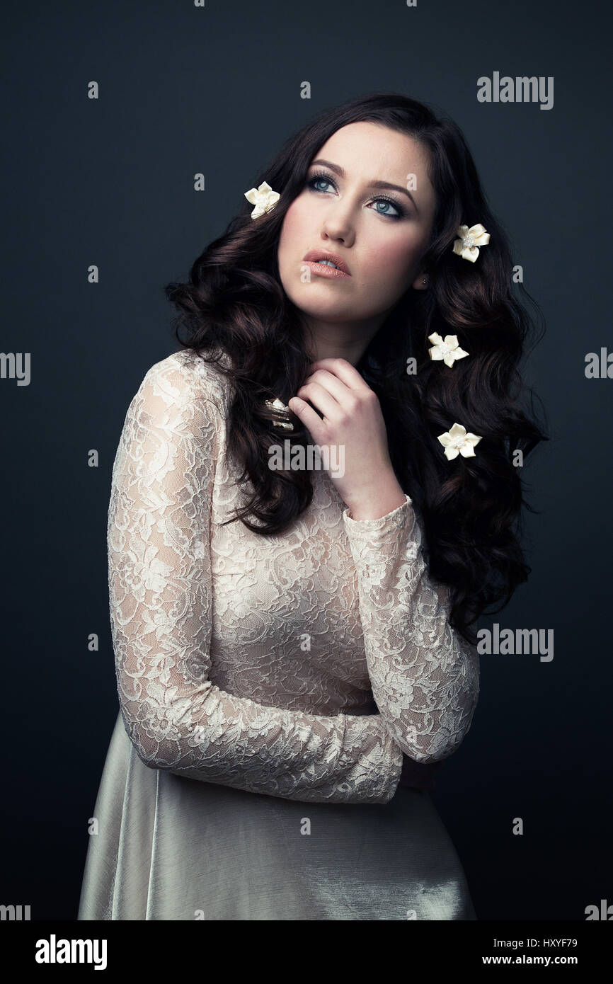Femme portant une robe en dentelle blanche est à l'écart, a des fleurs dans les cheveux Banque D'Images