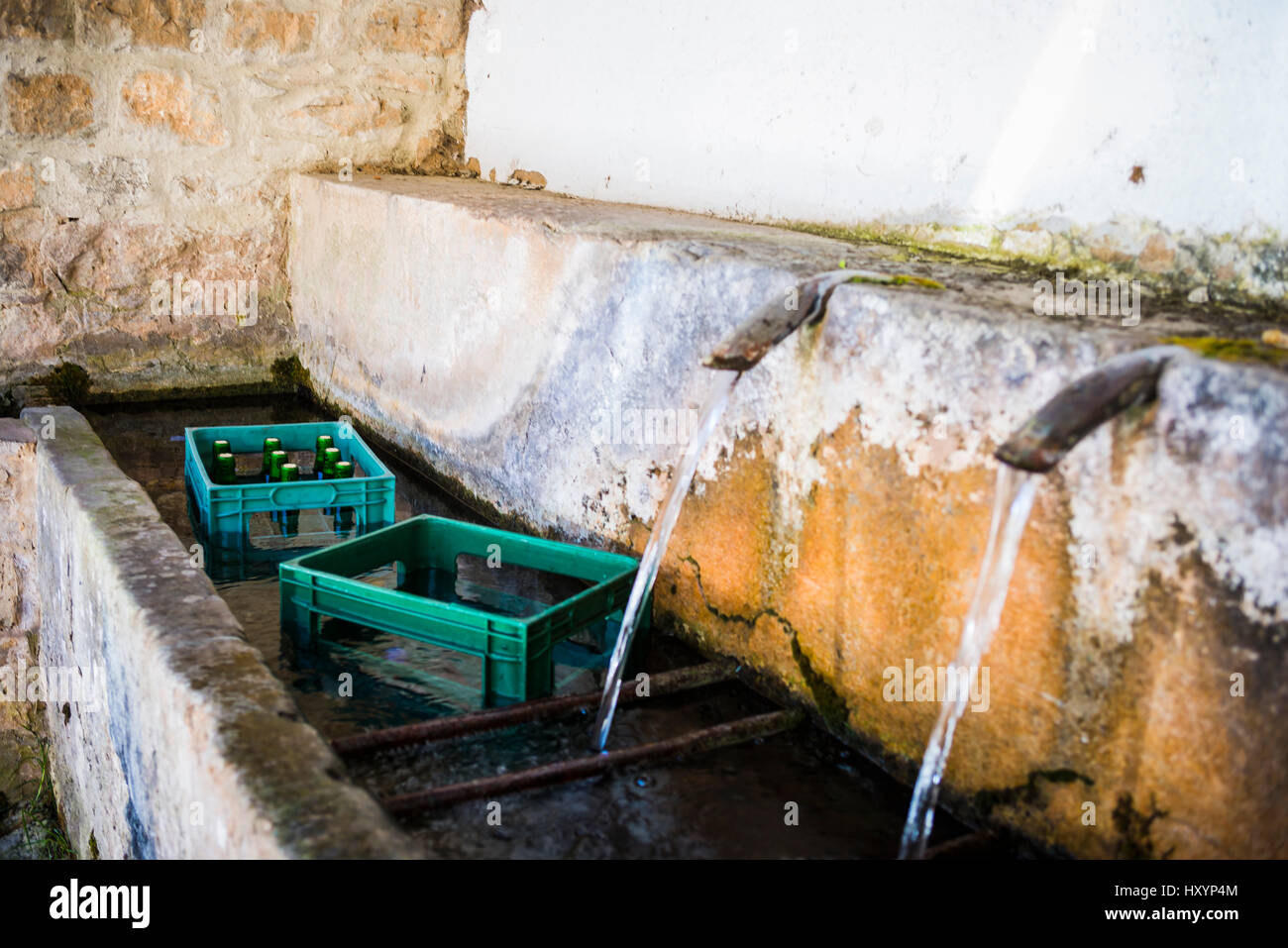 Bouteilles de cidre dans la fontaine. Saliencia, Somiedo, Principauté des Asturies, Espagne, Europe Banque D'Images