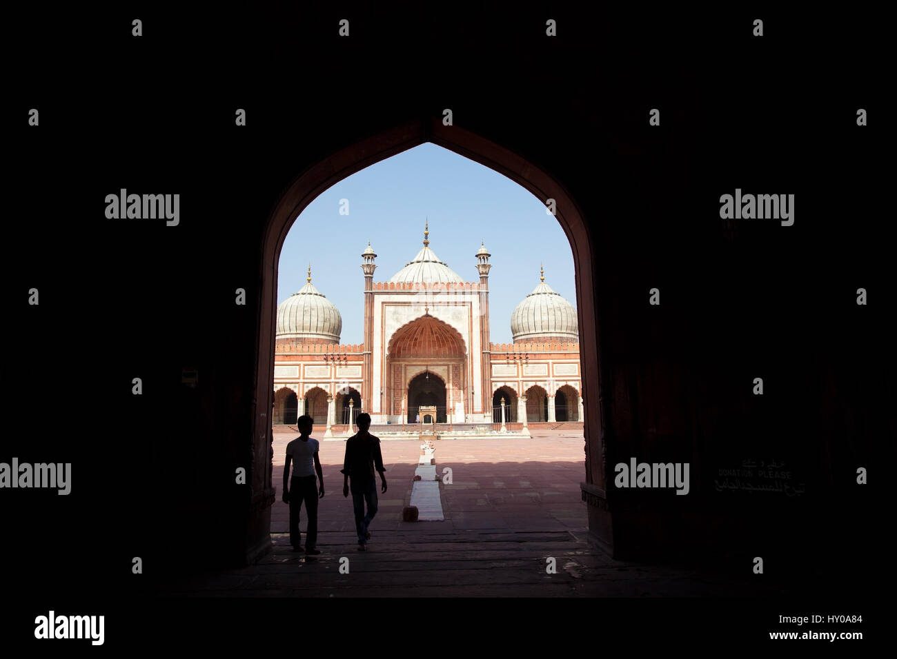 Les visiteurs de la mosquée Jama Masjid marche à travers arch, Delhi, Punjab, India Banque D'Images