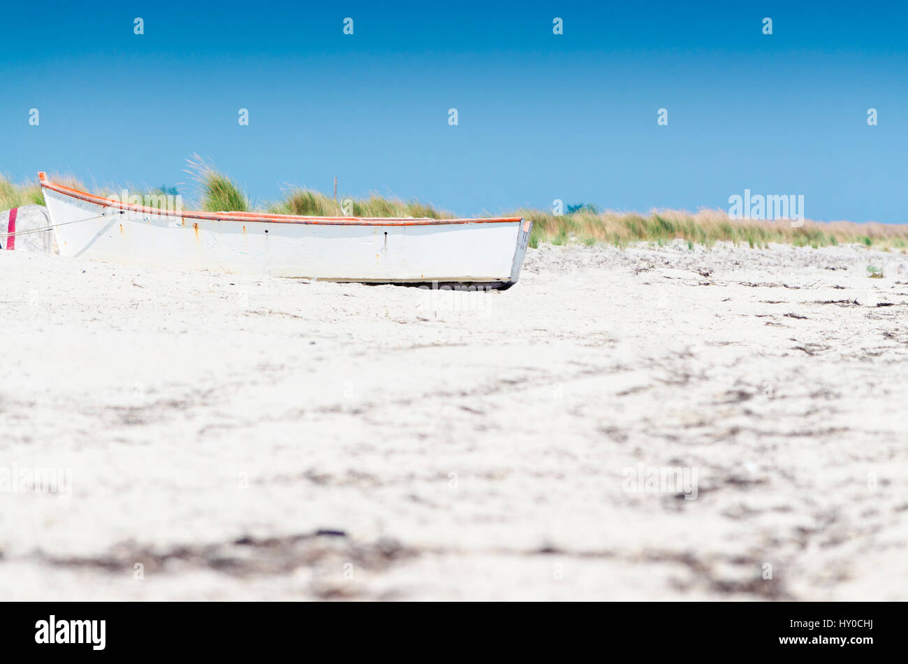 Petit bateau blanc sur la plage de sable Banque D'Images