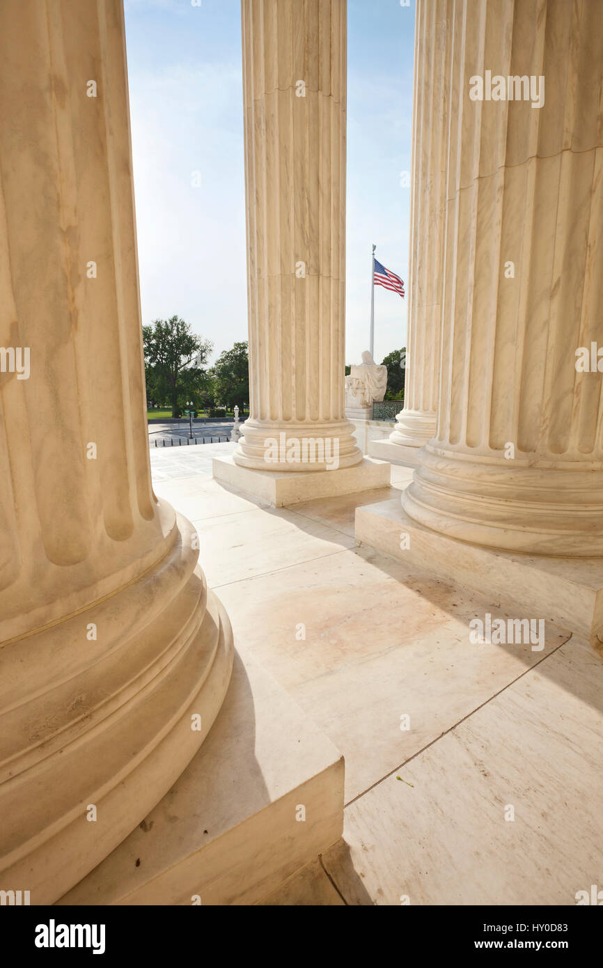 Drapeau américain vue entre les piliers de l'édifice de la Cour suprême à Washington DC Banque D'Images