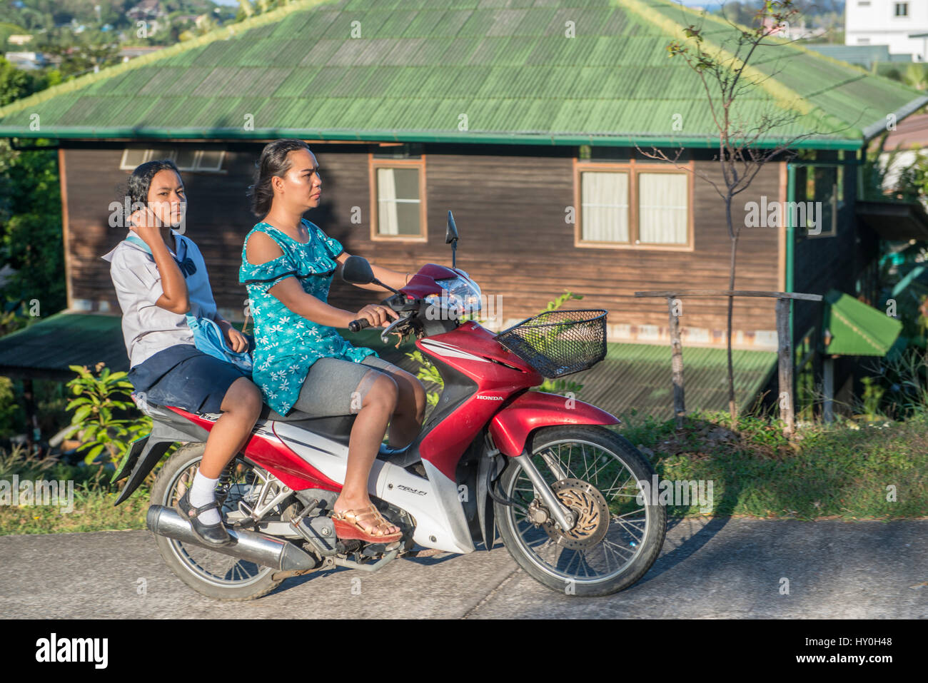 Une mère prend sa fille à l'école avec une moto en début de matinée à Phuket, Thaïlande. 10-Mar-2017 Banque D'Images