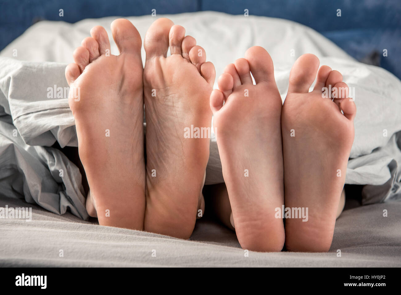 Close-up vue partielle des pieds nus de l'homme et de la femme au lit Photo  Stock - Alamy