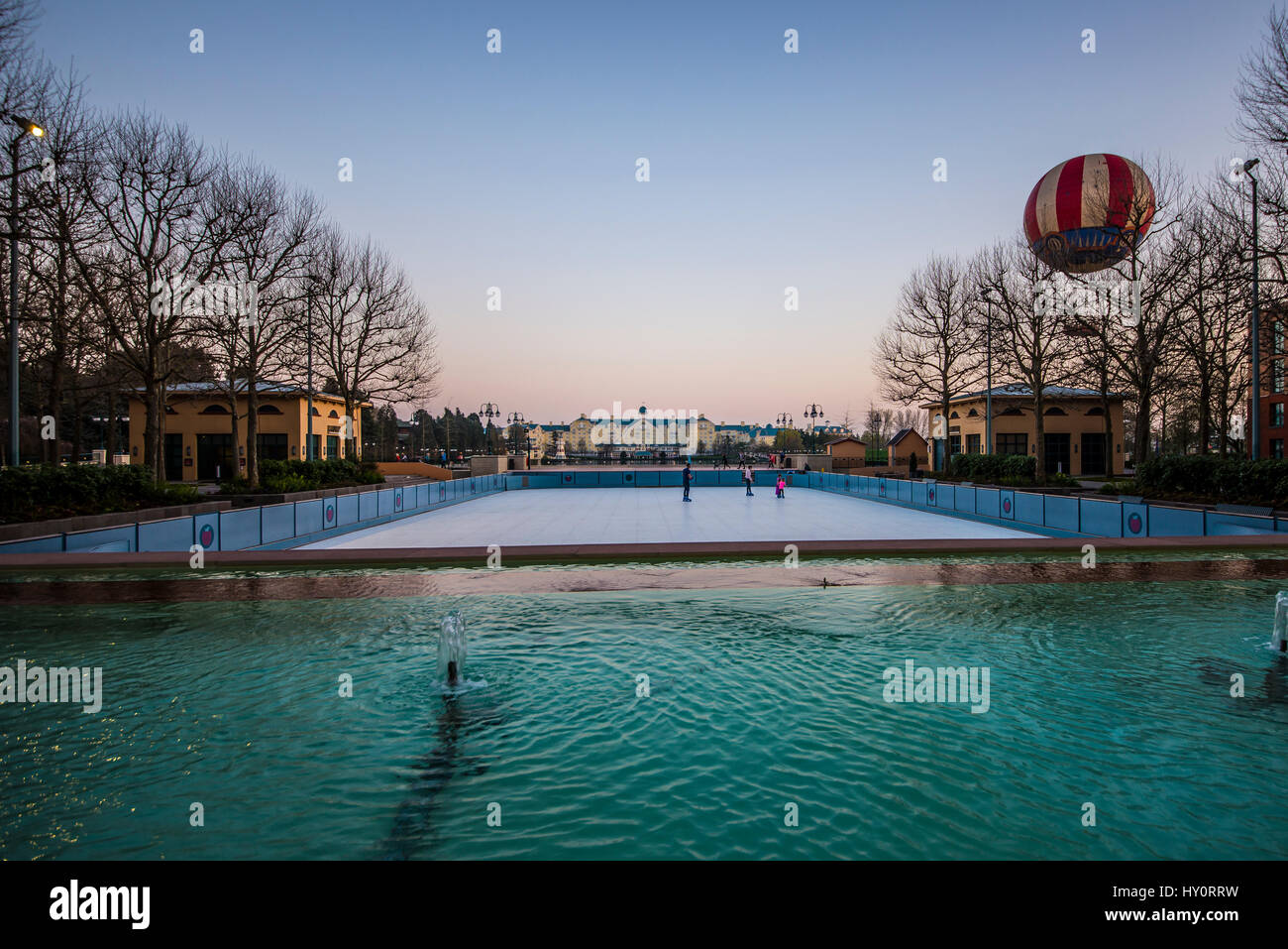 Hôtel Newport Bay Club et ballon panoramique à Disneyland Paris EuroDisney, vue de l'autre côté du lac Disney au crépuscule Banque D'Images