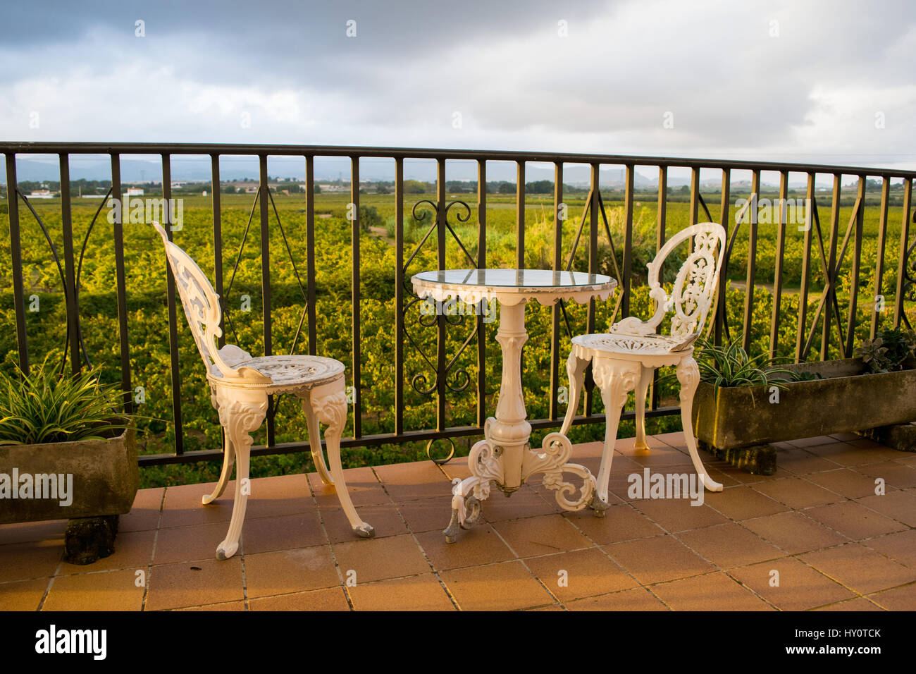 Vintage blanc, mobilier en fer forgé ensemble de jardinage vide table ronde  et deux chaises élégantes sur le balcon, vignobles dans l'arrière-plan  Photo Stock - Alamy