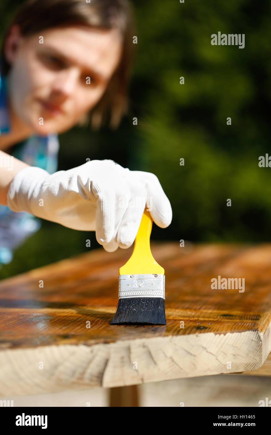 Femme chef de l'inspection de son travail après le traitement du bois avec la protection de la peinture. La protection de l'extérieur, menuiserie, dur au travail, le contrôle de qualité, accueil impr Banque D'Images