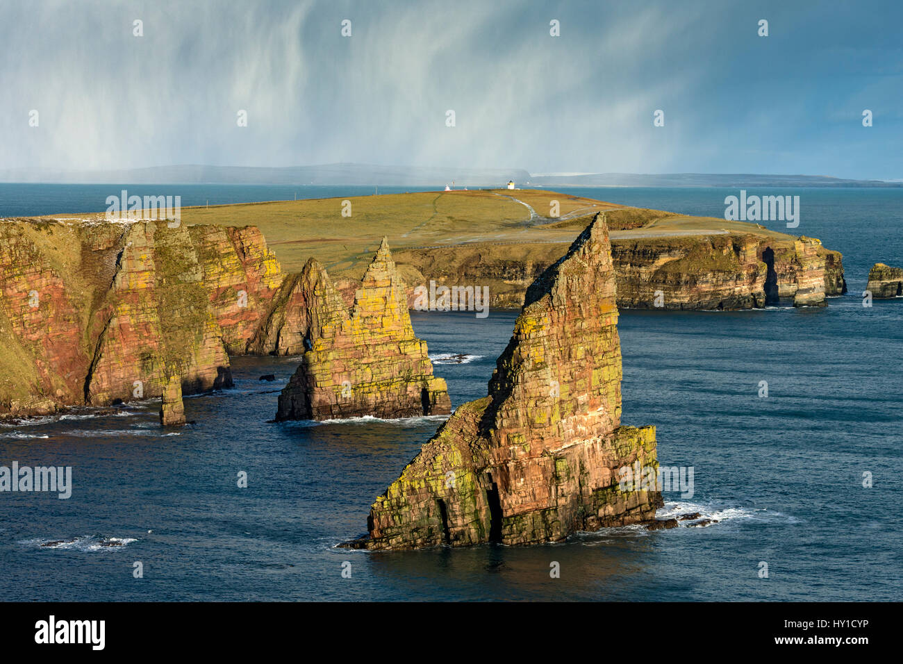 Les tas de Duncansby et Duncansby Head, près de John O' Groats, Caithness, Ecosse, Royaume-Uni. Averse de neige au cours de la distance dans le Pentland Firth. Banque D'Images