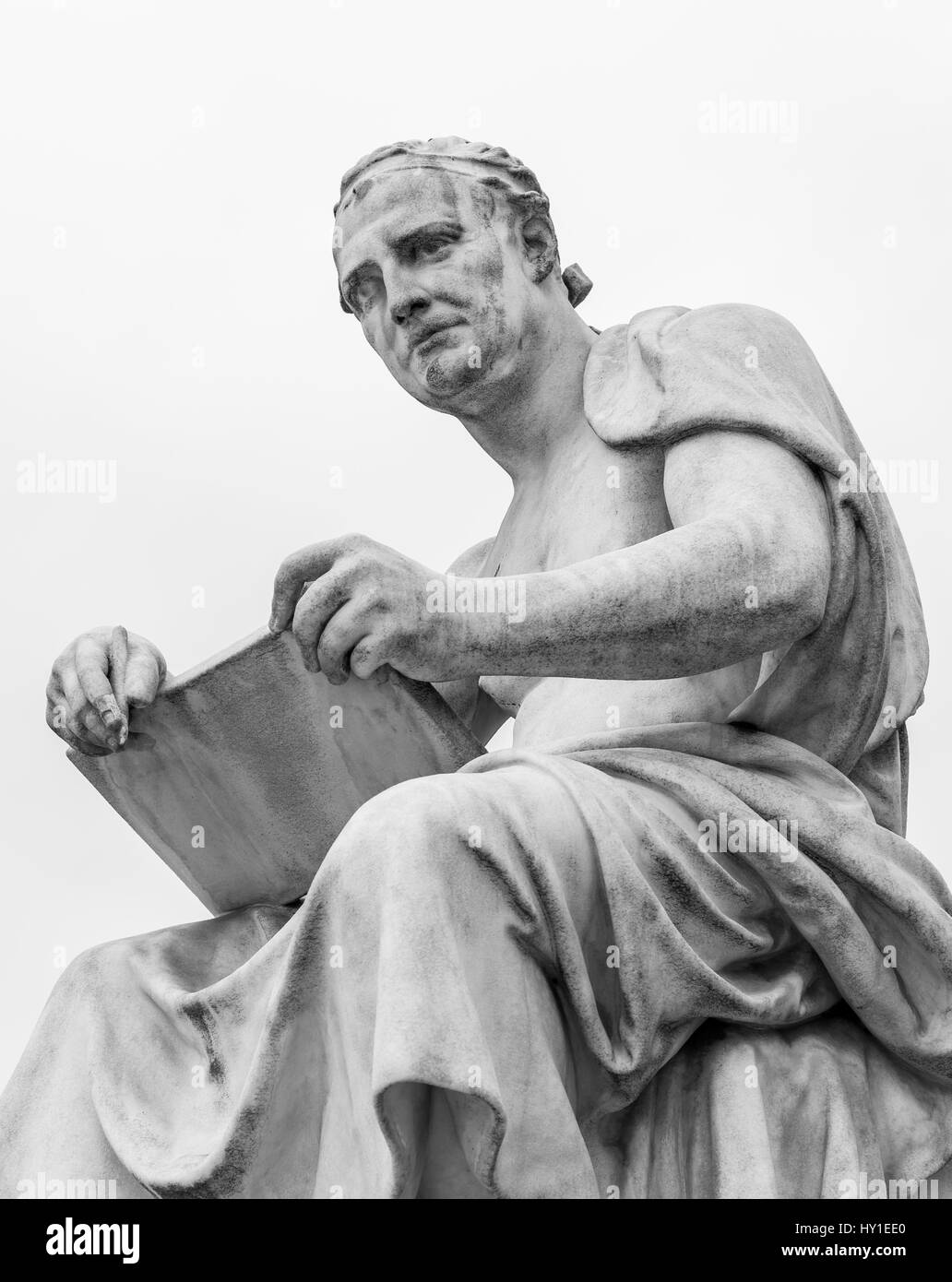 Un philosophe grec lève les yeux de son parchemin et se penche sur la distance. Cette statue est situé à l'extérieur du parlement autrichien à Vienne en Autriche. Banque D'Images