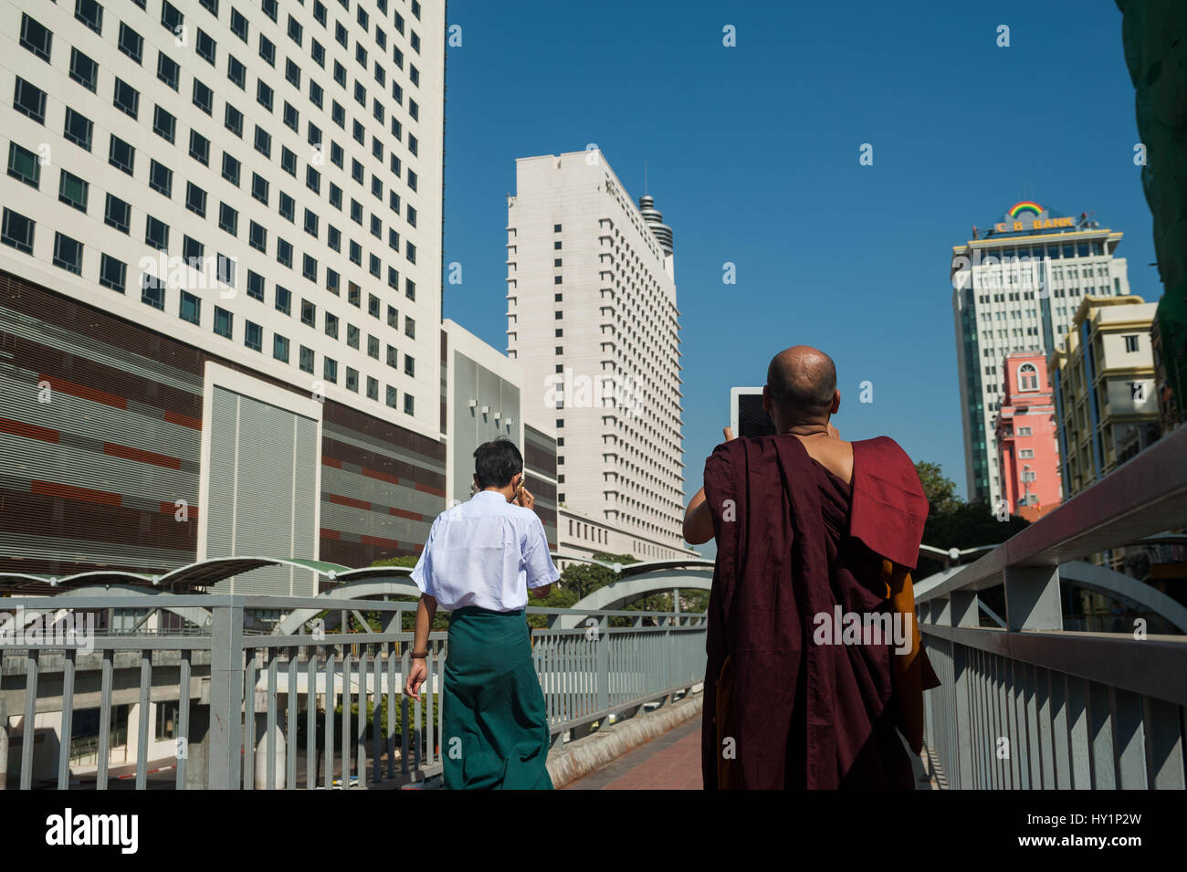 27.01.2017, Yangon, république de l'Union du Myanmar, de l'Asie - un moine bouddhiste se tient sur un pont piétonnier et prend des photos de la nouvelle place sule. Banque D'Images