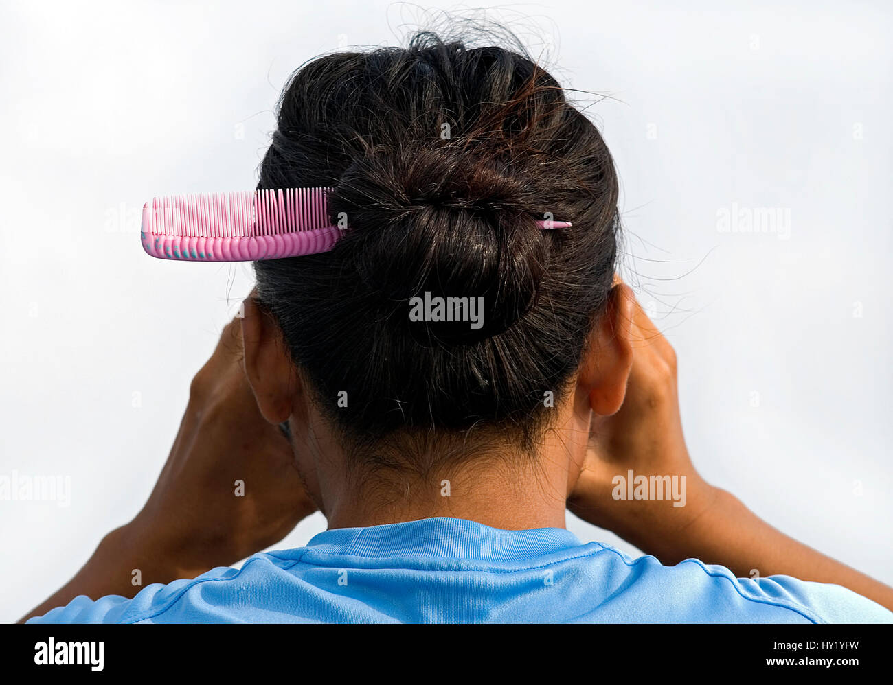 Ce stock photo montre un Ladyboyand ses cheveux de derrière, regardant à travers les jumelles. L'image a été prise par un après-midi ensoleillé. Banque D'Images