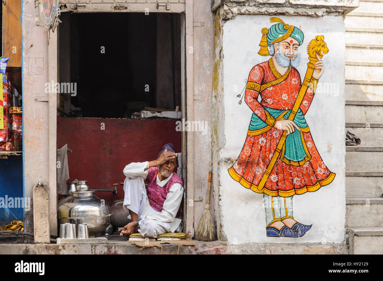 Chai wallah dans son échoppe à côté d'une peinture murale de Rajput dans Udaipur Banque D'Images