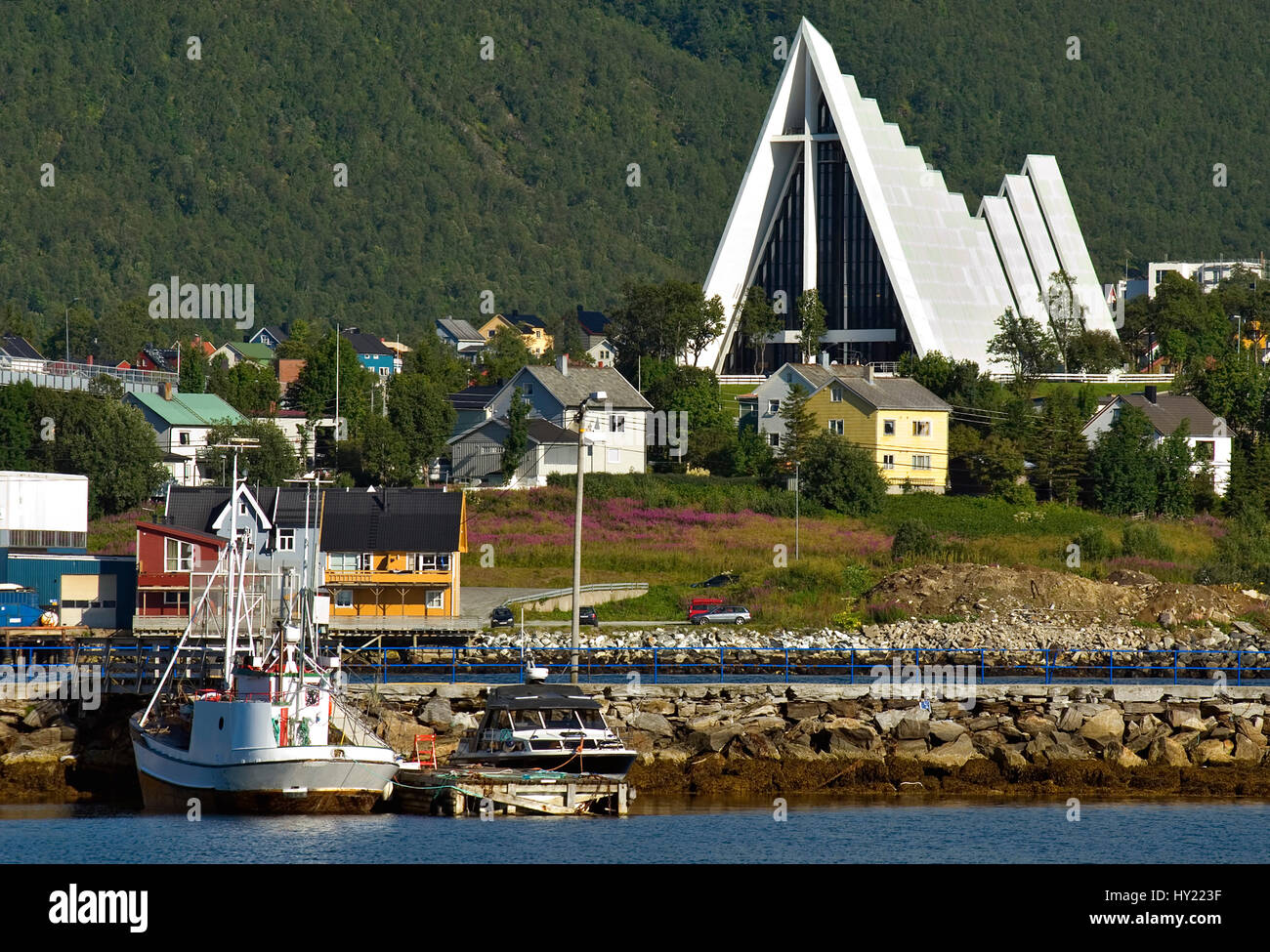Ce stock photo montre la cathédrale de la mer de glace dans le port de Tromsø en Norvège du Nord. En face vous pouvez voir des maisons colorées et des bateaux, avec l'I Banque D'Images