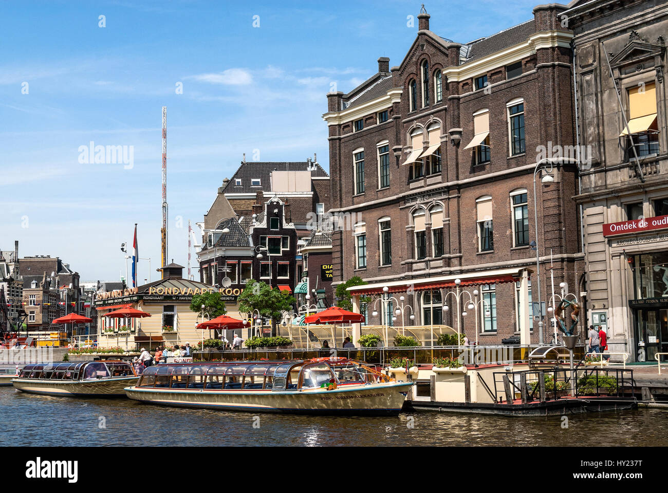 Des bateaux touristiques typiques dans un canal d'eau dans le centre-ville d'Amsterdam, Pays-Bas. Banque D'Images