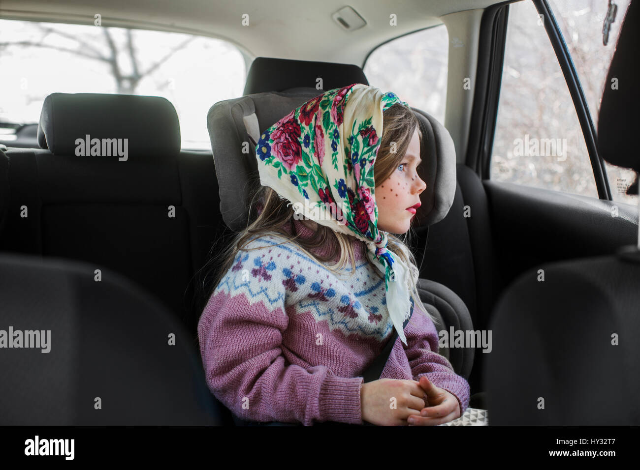 La Suède, Girl (4-5) habillé en sorcière Pâques assis en voiture et à la recherche d'une fenêtre Banque D'Images