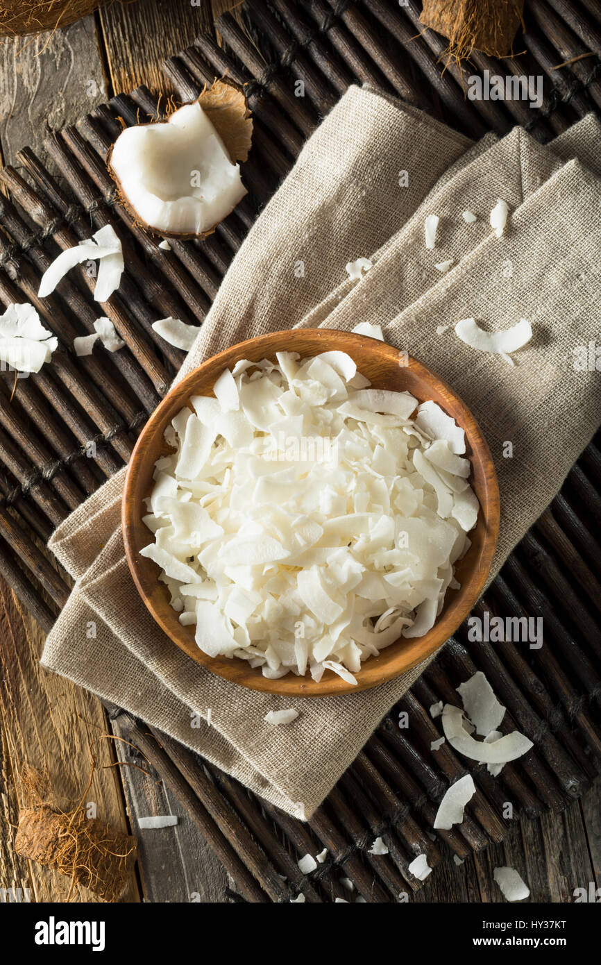 Flocons de noix de coco biologiques crus dans un bol pour la cuisson Banque D'Images