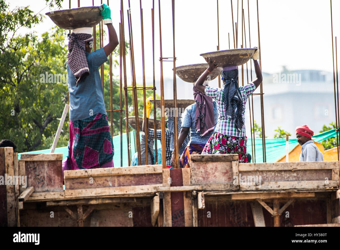 Des femmes portant des charges lourdes sur un site de construction à Chennai, Inde Banque D'Images