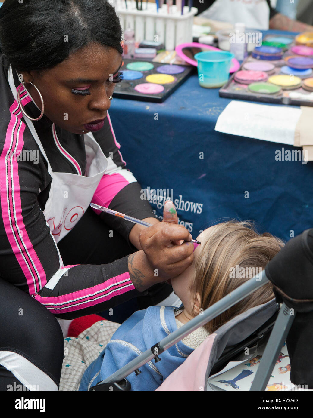 Peinture peintre Afro-américains font face à un visage d'enfant dans un événement - USA Banque D'Images