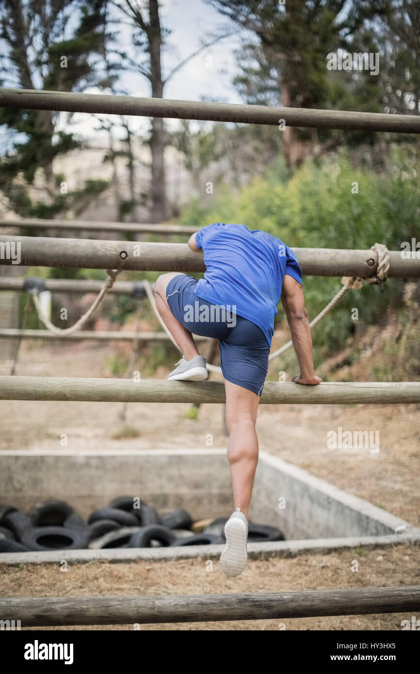 Man crossing la corde au cours de parcours dans boot camp Banque D'Images