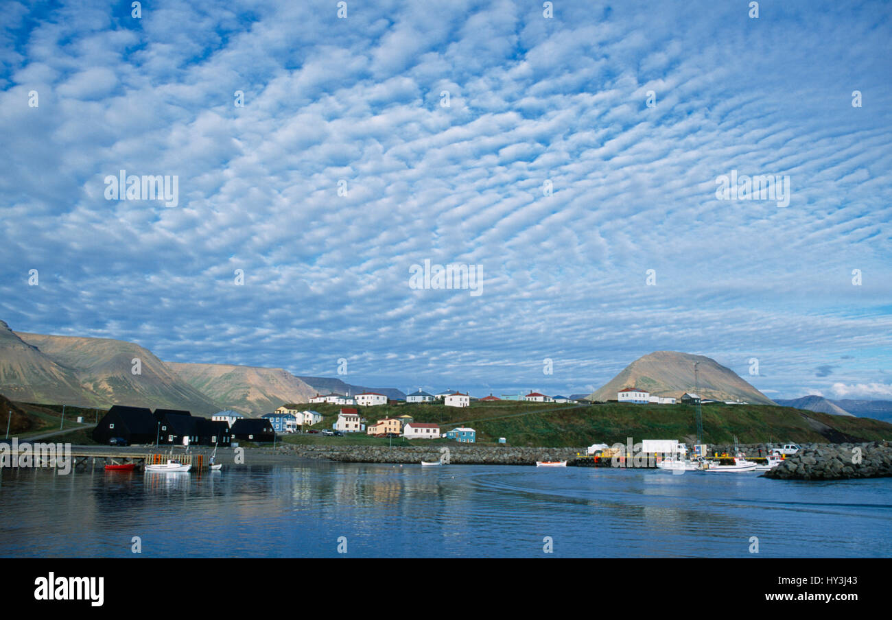 L'Islande, l'île de Hofsos Skagafjorour, village de bord de mer, avec des bateaux sur l'eau et les maisons construites le long du littoral. Banque D'Images