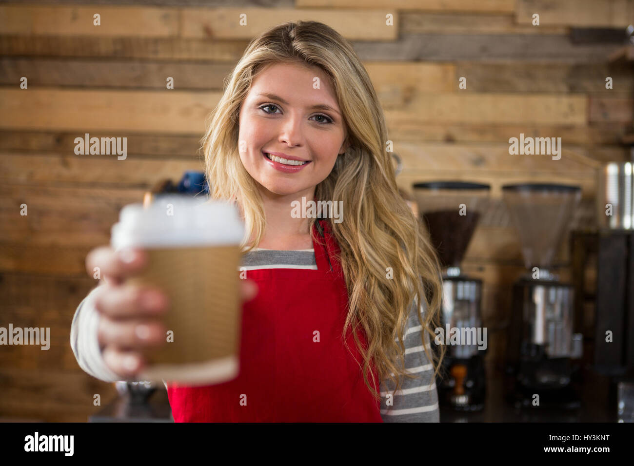 Portrait of young female barista holding Coffee cup in cafe jetables Banque D'Images