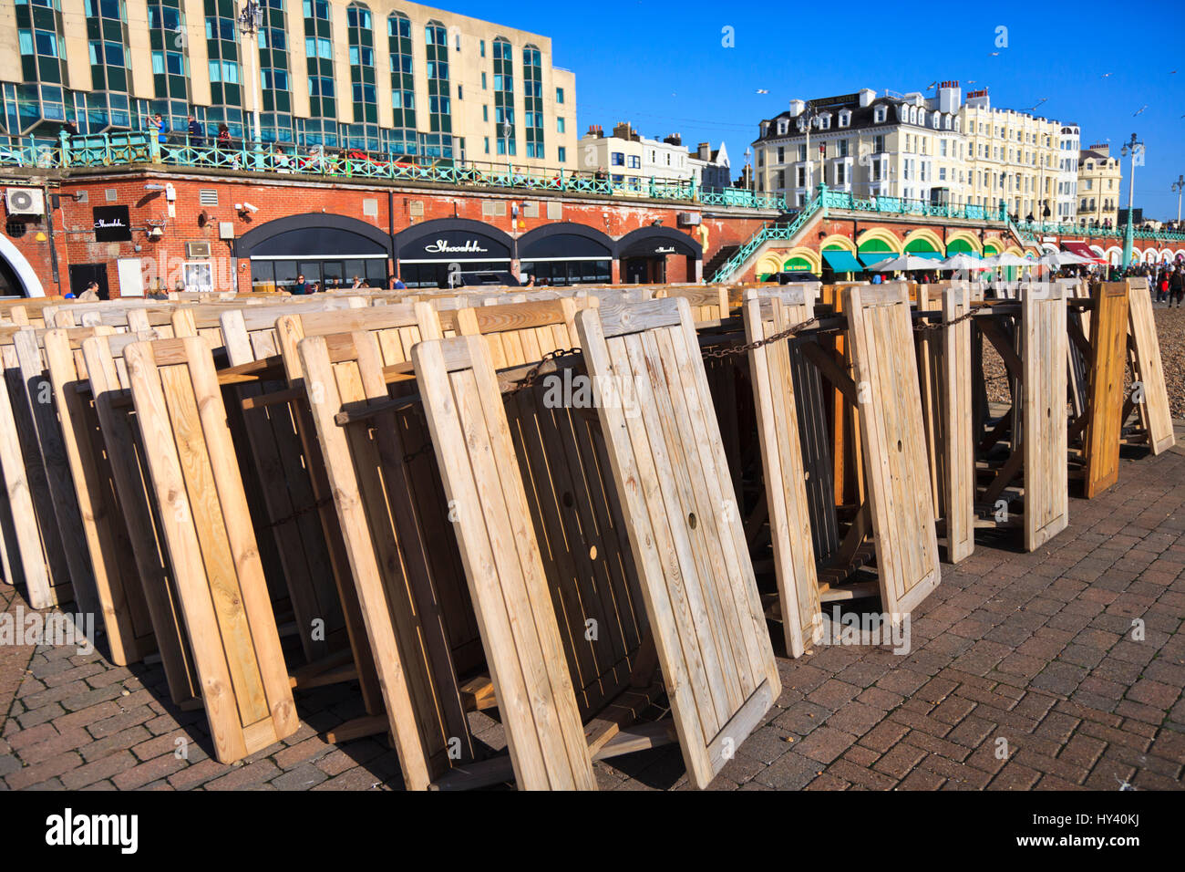 Tables et chaises en bois empilés mois ebeachfront à Brighton, East Sussex, Angleterre Banque D'Images